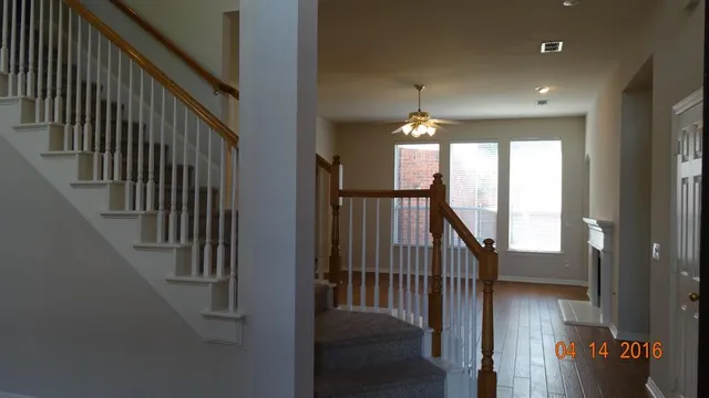 a view of a hallway with wooden floor and stairs