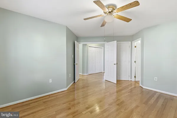 a view of a room with a ceiling fan and wooden floor