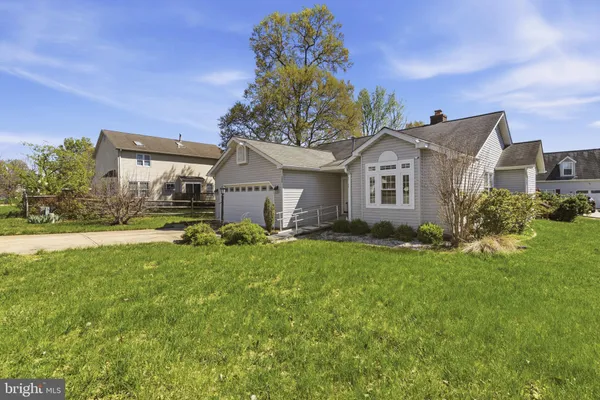 a front view of a house with a yard and trees