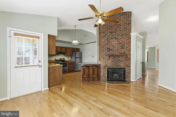 a view of open kitchen with granite countertop a refrigerator and a stove top oven
