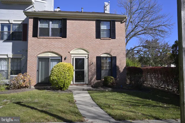 a view of a house with brick walls and a yard with plants