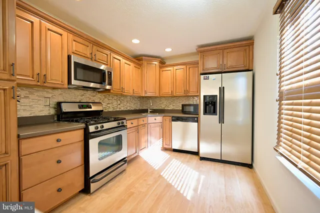 a kitchen with stainless steel appliances granite countertop a refrigerator stove and microwave