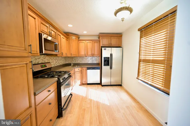 a kitchen with stainless steel appliances granite countertop a stove a sink and a refrigerator
