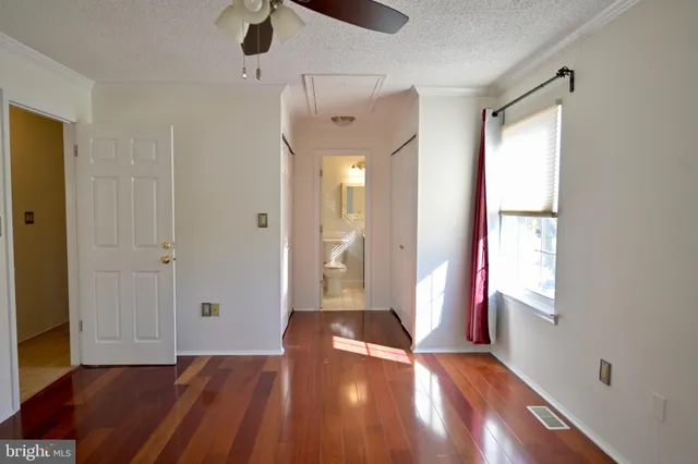 a view of an empty room with window and wooden floor