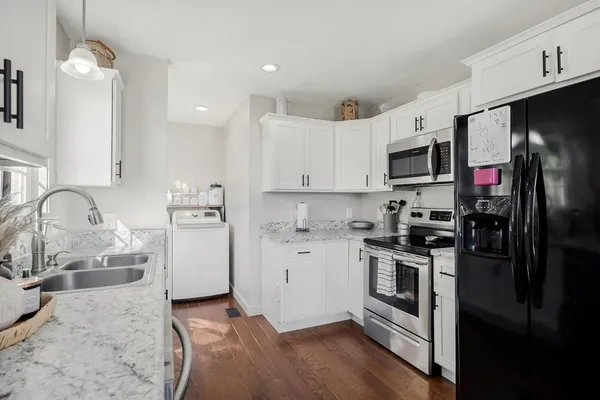 a kitchen with granite countertop a refrigerator stove and sink