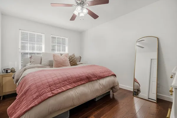 a bedroom with a bed and wooden floor