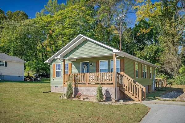 a view of a house with a yard and fence