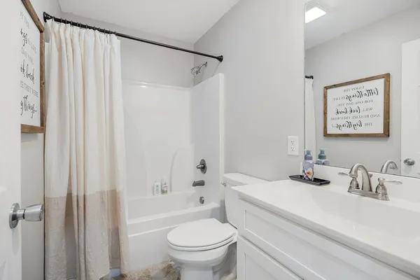 a bathroom with a sink a toilet and shower curtain