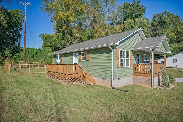 a view of a house with a yard and deck
