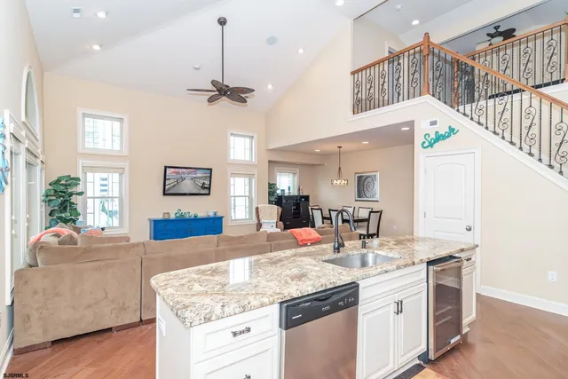 a kitchen with stainless steel appliances kitchen island granite countertop a sink cabinets and wooden floor