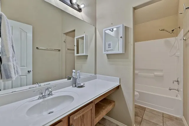 a bathroom with a granite countertop sink a mirror and a bathtub