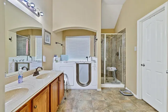 a bathroom with a granite countertop sink a mirror and shower