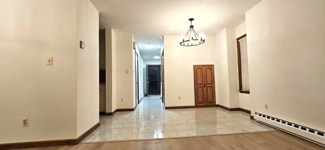 an empty room with wooden floor and mirror