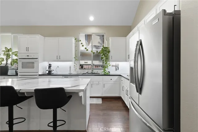 a kitchen with stainless steel appliances granite countertop a refrigerator a stove a sink and a stove