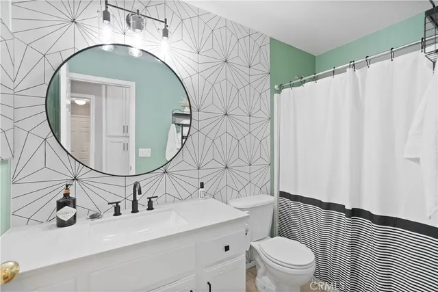 a bathroom with a sink vanity mirror and toilet
