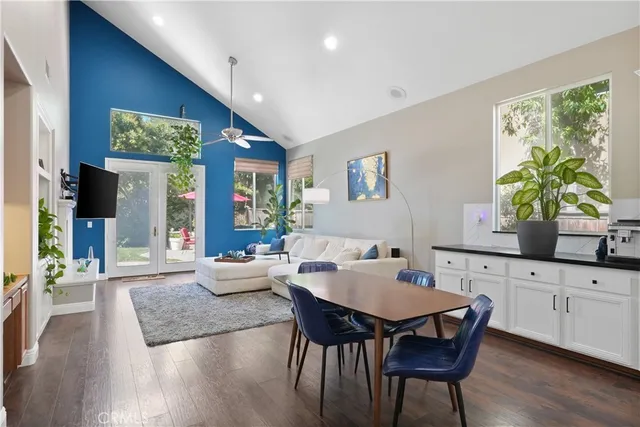 a living room with furniture a flat screen tv and a large window
