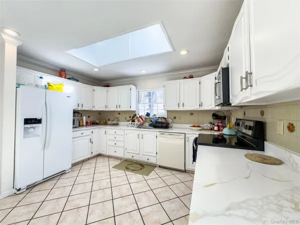 a kitchen with a sink a stove cabinets and utility room