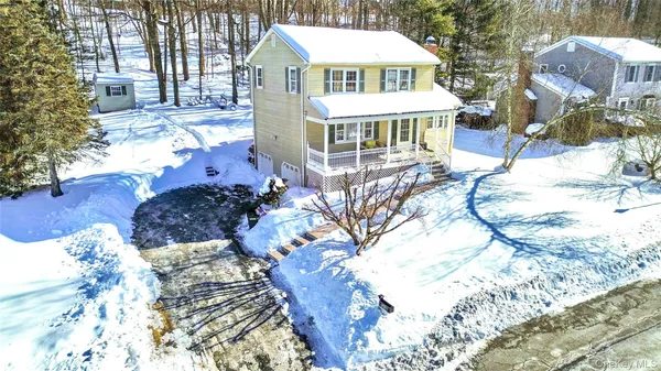a front view of a house with a yard covered with snow