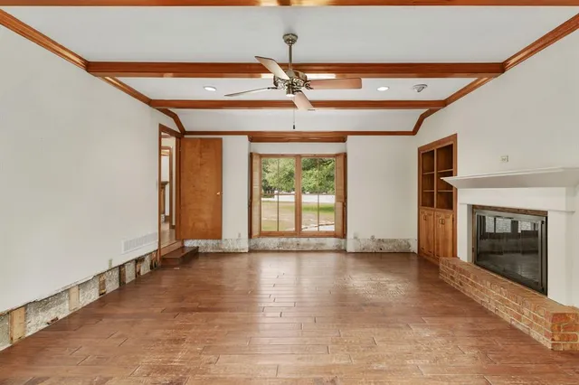 a view of an empty room with a fireplace and a window