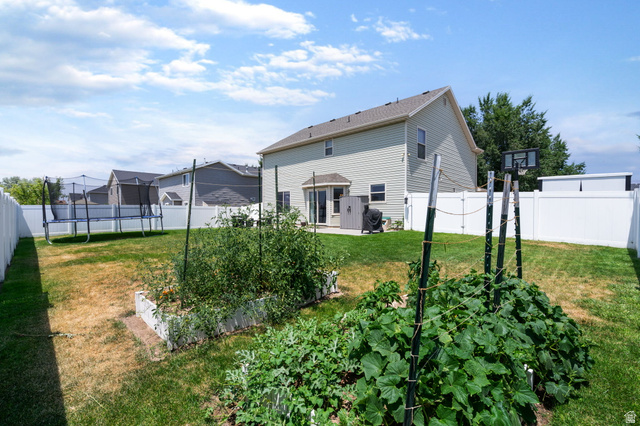 1393 West 150 North Springville, UT 84663 - Photo 20 of 31 Expansive backyard featuring a privacy fence, established garden beds, and a concrete patio