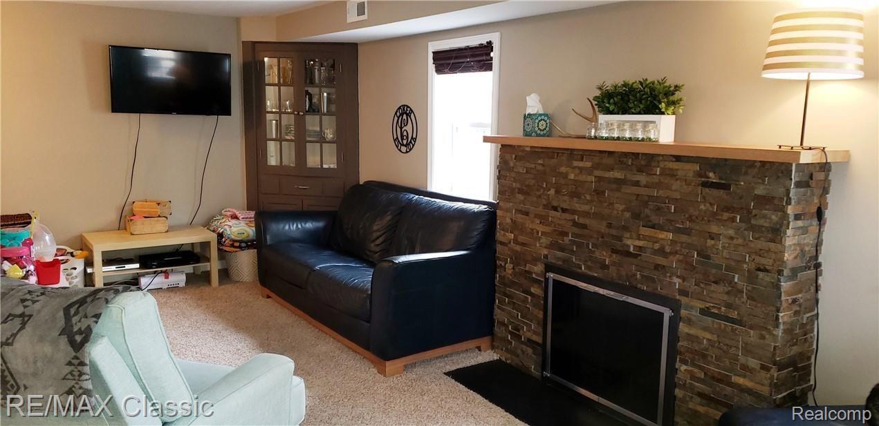 Family room with built in corner cabinet, natural fireplace and lots of light