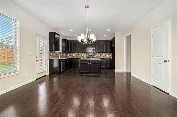 a view of a kitchen and dining room with wooden floor a fireplace