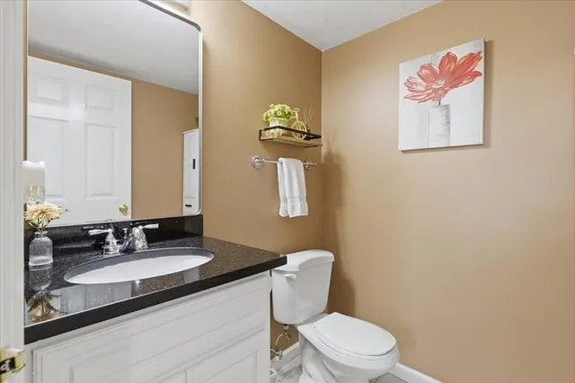 a bathroom with a granite countertop toilet sink and mirror