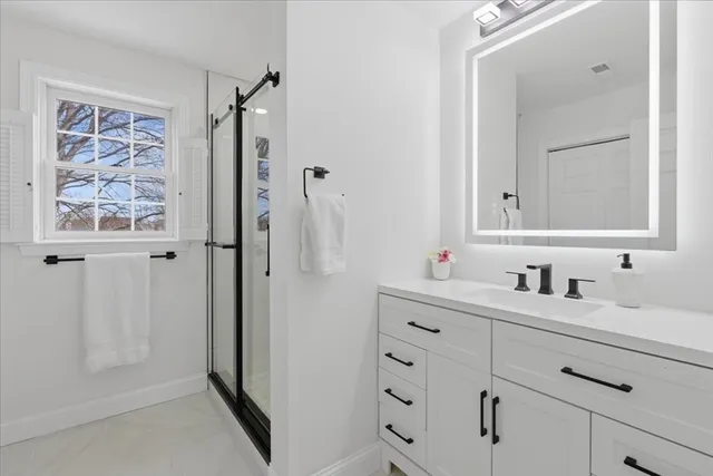 a bathroom with a shower sink and mirror