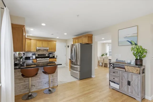 a kitchen with stainless steel appliances kitchen island granite countertop a refrigerator and a stove top oven