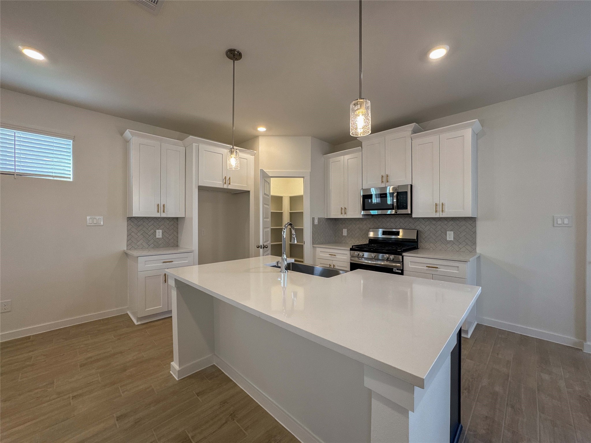 1115 Santee Court Rosharon, TX 77583 - Photo 5 of 24 a kitchen with a sink a stove a refrigerator and white cabinets