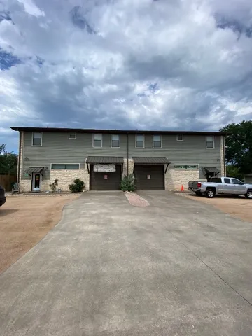 a front view of a house with cars parked