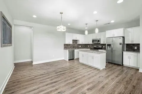 a kitchen with granite countertop a sink stove and refrigerator