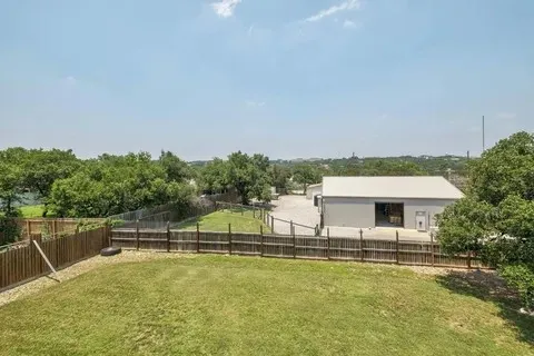 a view of a swimming pool with lawn chairs and a yard