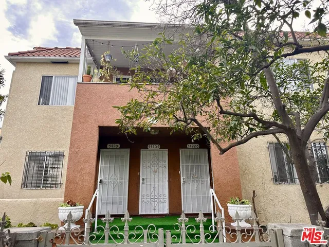 a front view of a house with plants and entryway