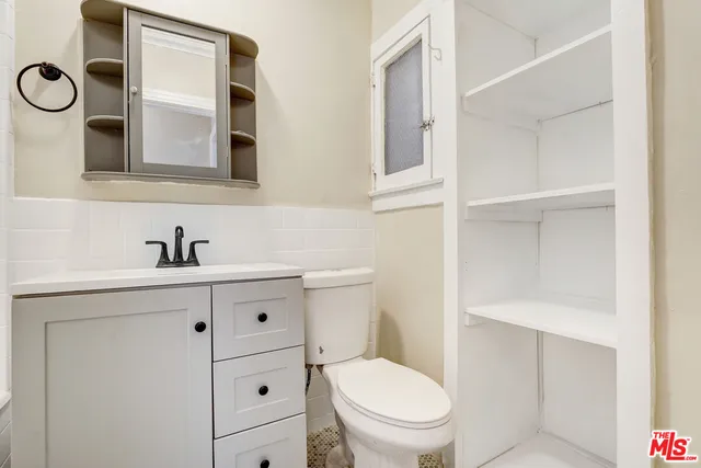 a bathroom with a toilet a sink a vanity and mirror