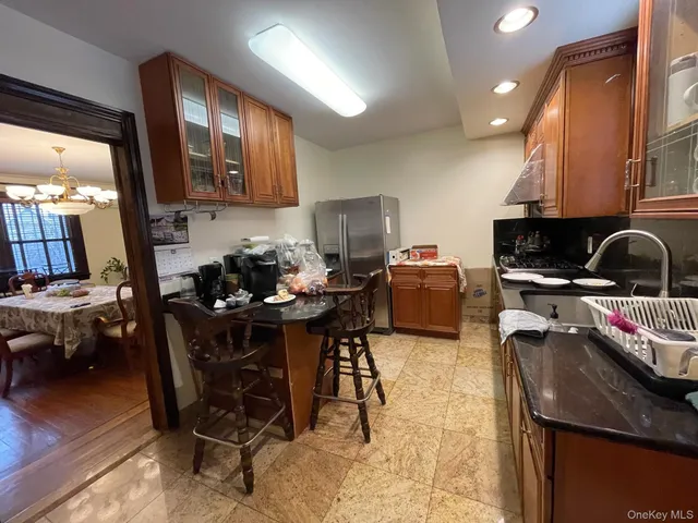 a kitchen with a sink a stove and a dining table with chairs