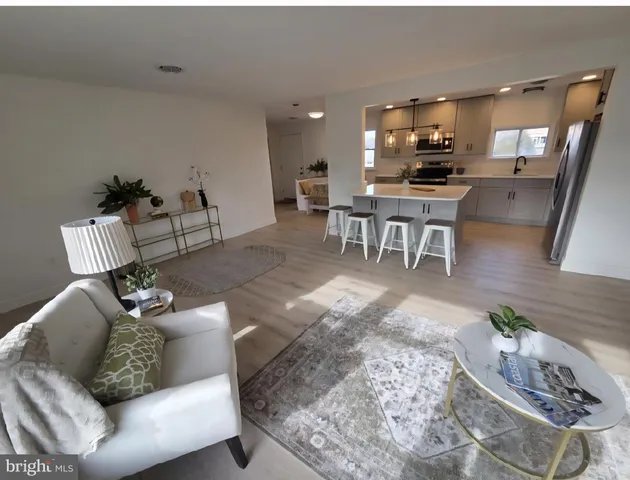 a living room with furniture and a dining table with kitchen view