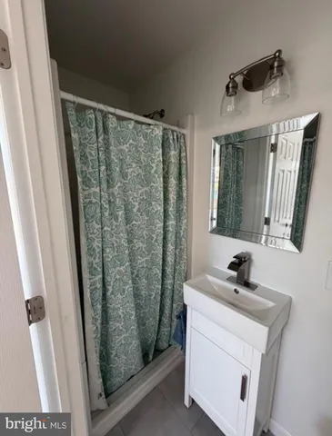 a bathroom with a sink a mirror a vanity and a shower