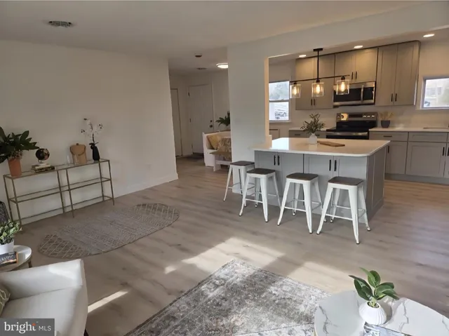 a large white kitchen with lots of white furniture and appliances