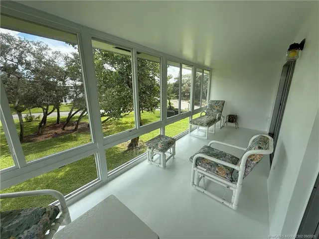 a living room with a floor to ceiling window and a floor to ceiling window