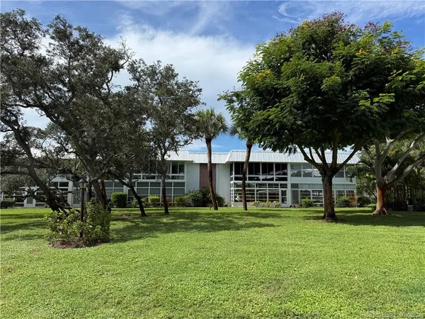 a view of a house with a big yard and large trees