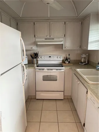 a kitchen with a stove top oven a sink and white cabinets