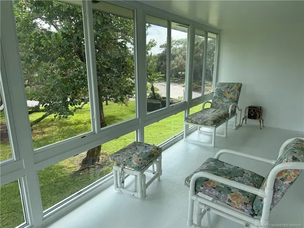 a living room with furniture and a floor to ceiling window