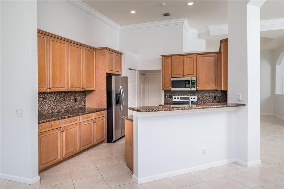 3759 Oak Ridge Circle Weston, FL 33331 - Photo 14 of 31 a kitchen with stainless steel appliances granite countertop a refrigerator and a stove top oven