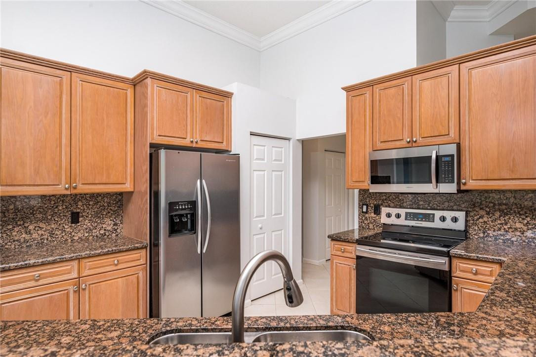 3759 Oak Ridge Circle Weston, FL 33331 - Photo 15 of 31 a kitchen with stainless steel appliances granite countertop a refrigerator stove and oven