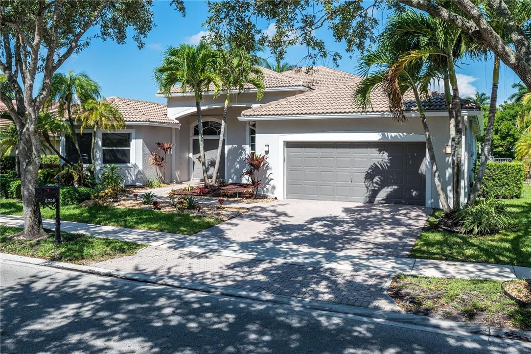 3759 Oak Ridge Circle Weston, FL 33331 - Photo 2 of 31 a front view of a house with garden