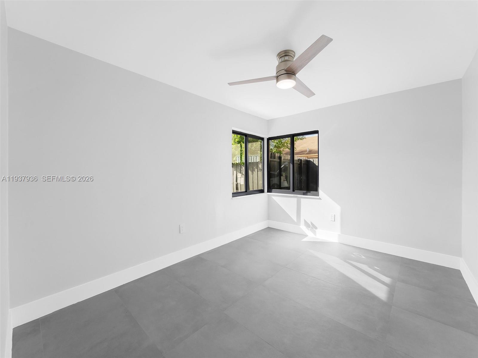212 Southwest 7th Street Hallandale Beach, FL 33009 - Photo 14 of 23 an empty room with windows and fan
