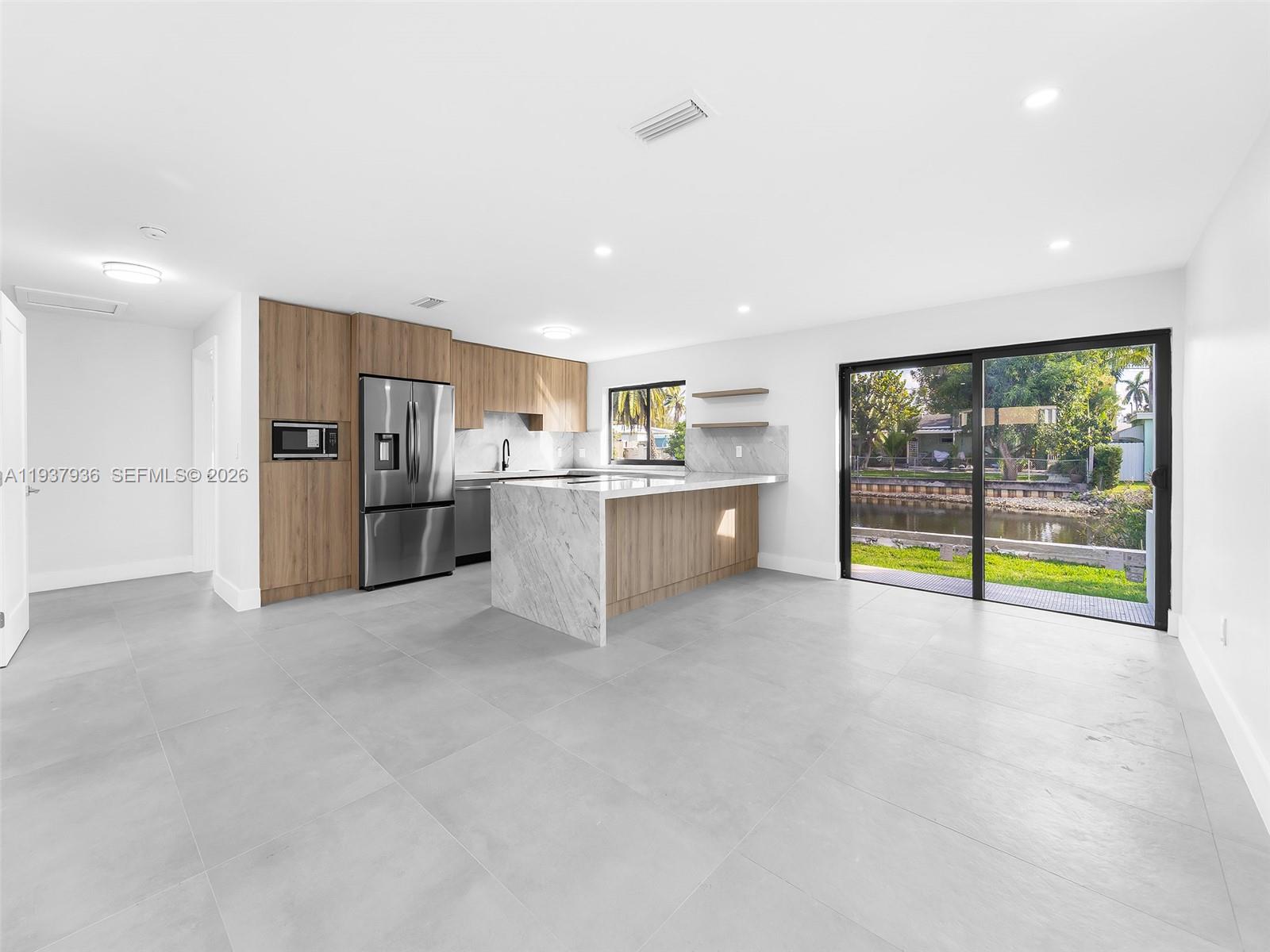 212 Southwest 7th Street Hallandale Beach, FL 33009 - Photo 3 of 23 a view of a kitchen with a sink and refrigerator