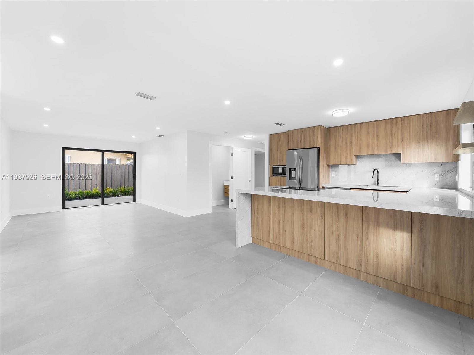 212 Southwest 7th Street Hallandale Beach, FL 33009 - Photo 4 of 23 a kitchen with stainless steel appliances granite countertop a refrigerator a sink a stove and a refrigerator with wooden floor