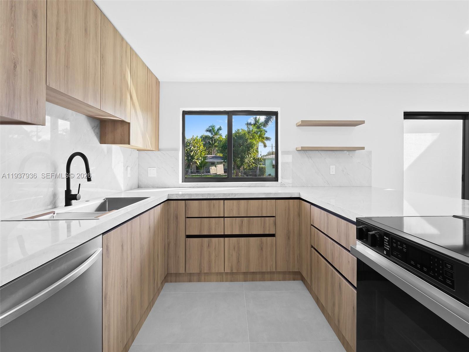 212 Southwest 7th Street Hallandale Beach, FL 33009 - Photo 5 of 23 a kitchen with a sink stove and cabinets